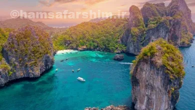 منظره هوایی از طبیعت بکر جزایر فی فی یا کرابی تایلند با صخره‌های آهکی و آب‌های فیروزه‌ای 🌊⛰️